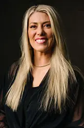 Woman with long blonde hair wearing a black top at Salon M + Suites. Woman with long blonde hair wearing a black top at Salon M + Suites.