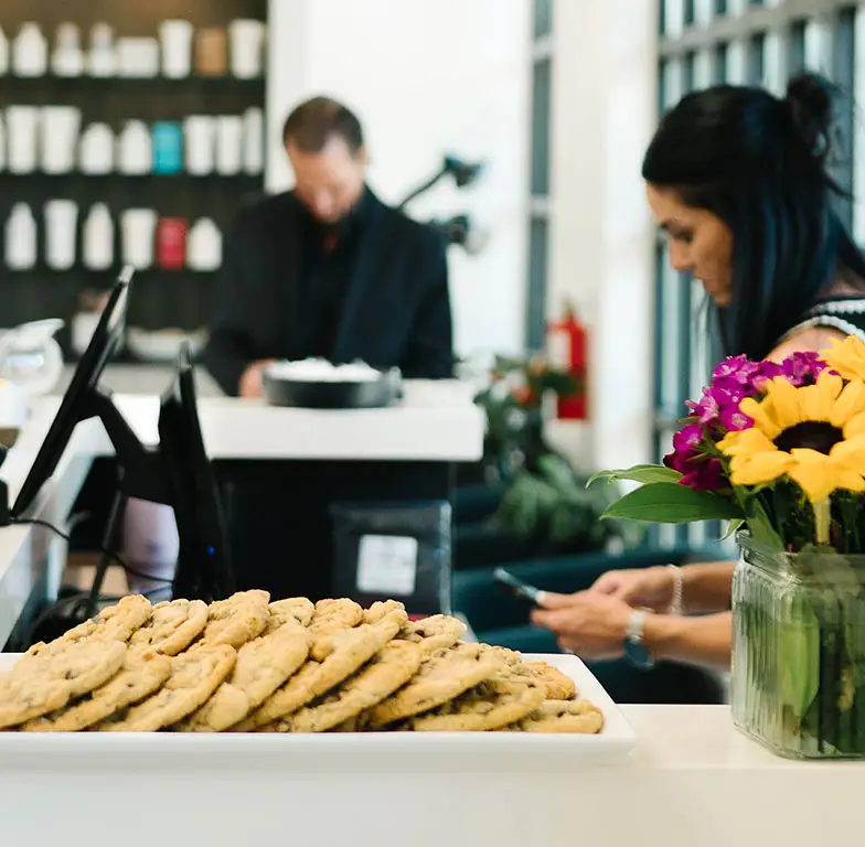 Woman standing in front of counter with cookies at Salon M + Suites. Woman standing in front of counter with cookies at Salon M + Suites.