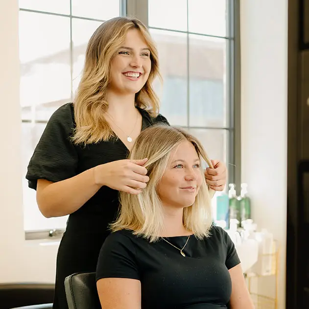 Haircut at Salon M + Suites American Fork A woman getting her hair cut by another woman at Salon M + Suites American Fork.