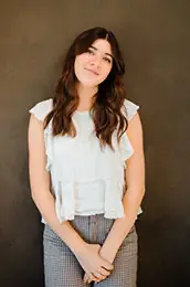A woman in a white top and checkered pants. A woman in a white top and checkered pants.