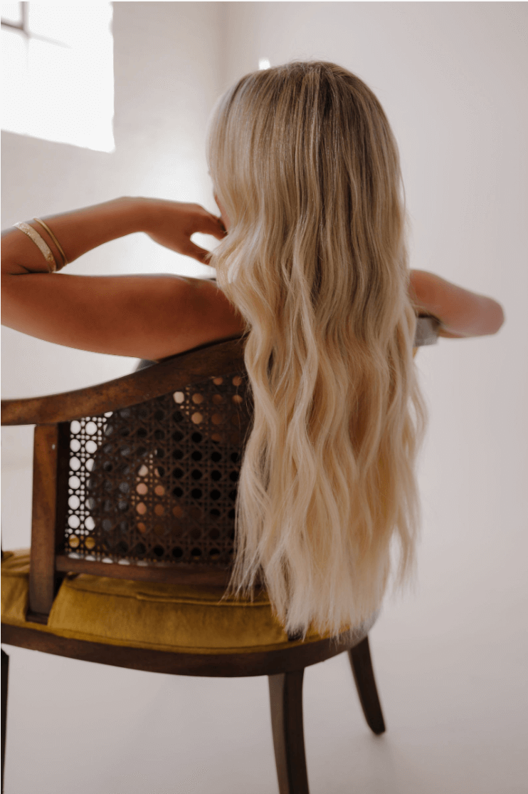 Blonde girl sitting in a chair with her hair laying over the chair