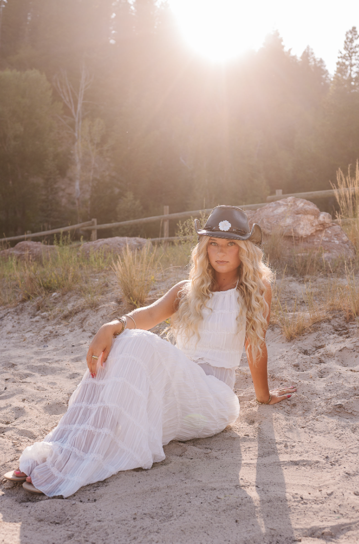 Blonde hair girl sitting in the sand and sun