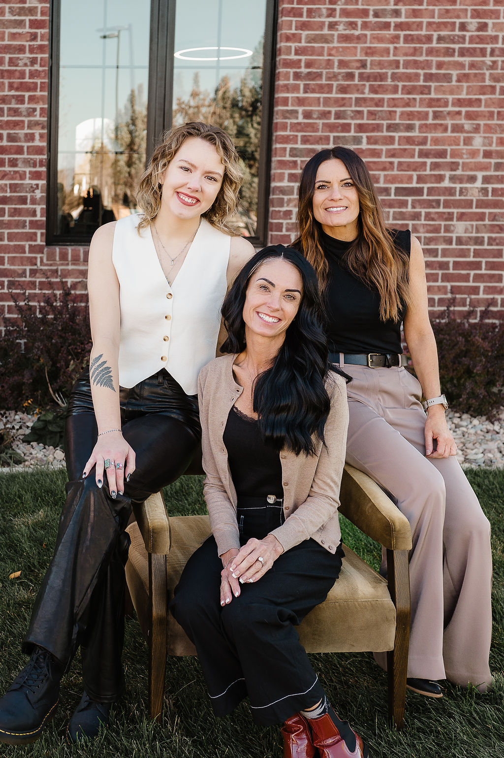 Two women in black dresses embracing each other warmly, displaying a strong bond of friendship and support.