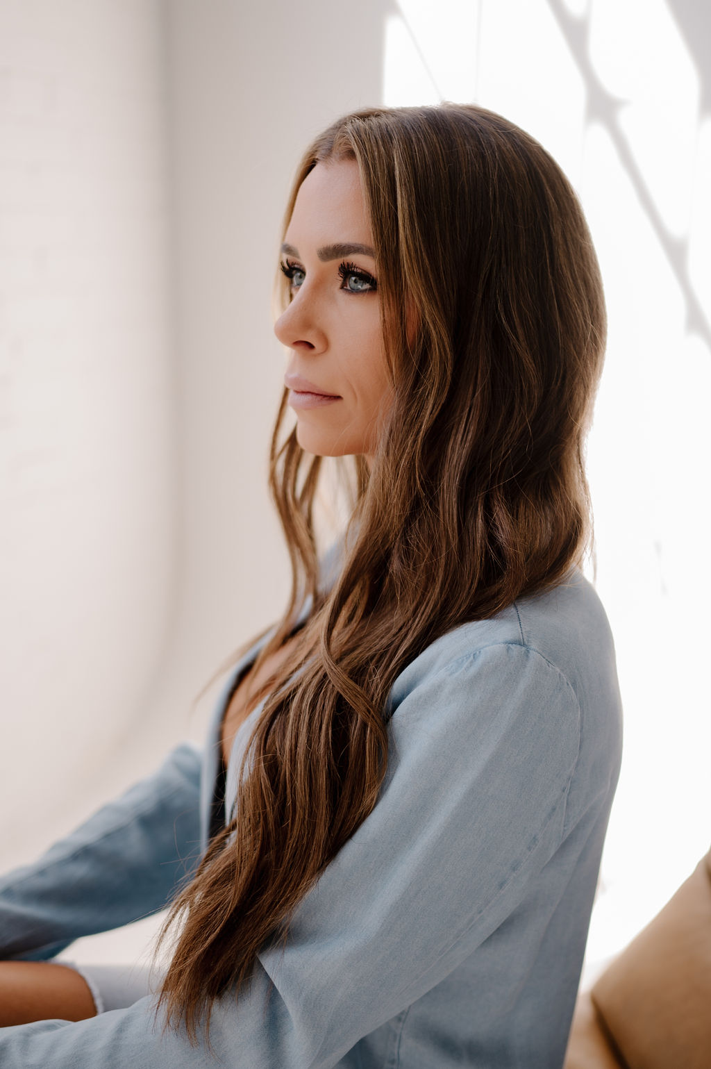 Blonde woman posing for a photo, showcasing her long hair.