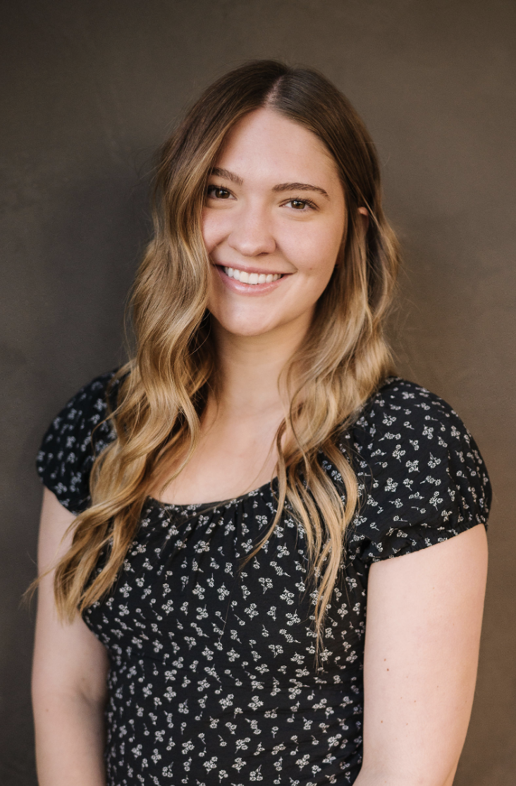 A woman with long blonde hair wearing a black shirt.